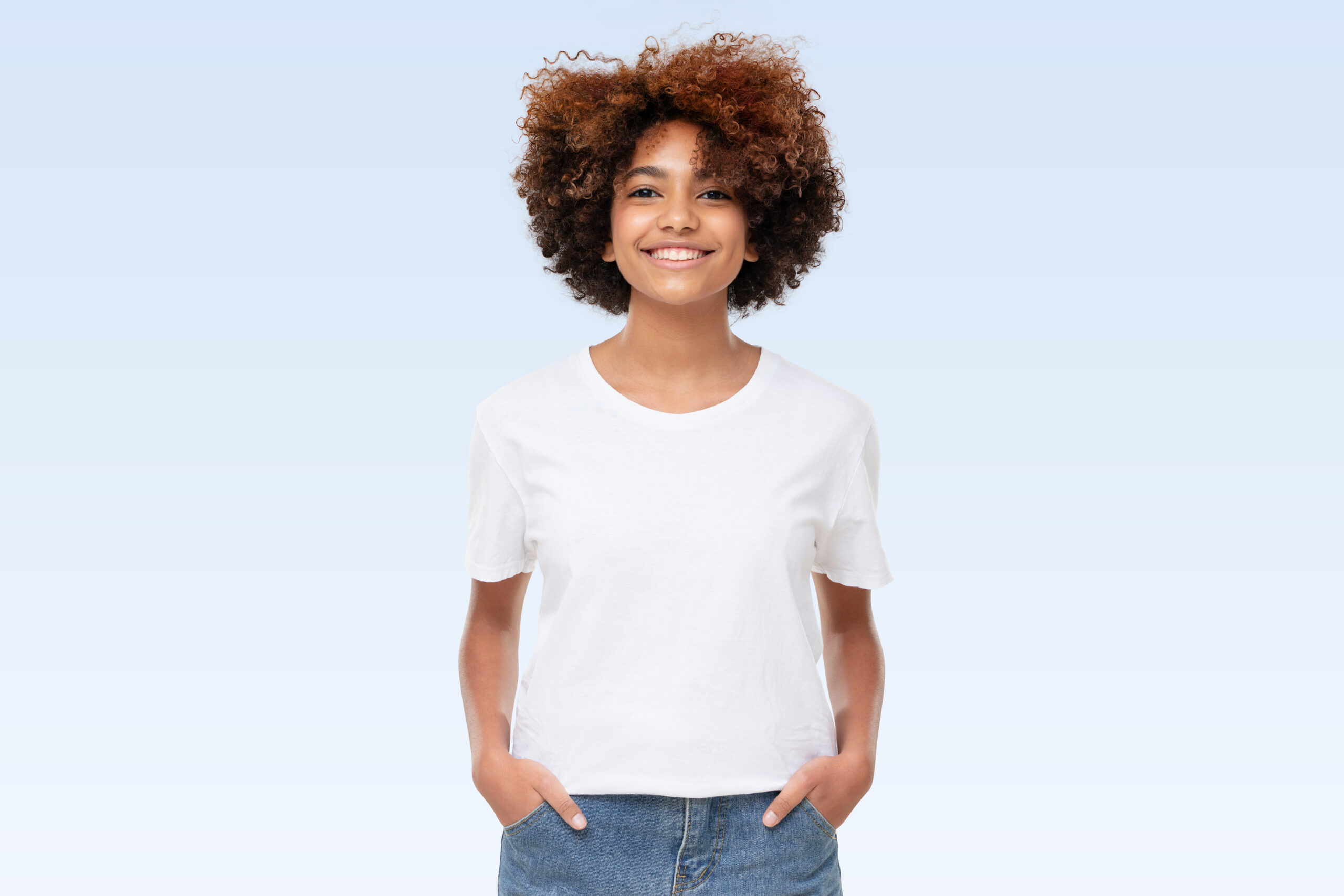 Front view of african american girl standing with hands in pockets, wearing blank t-shirt