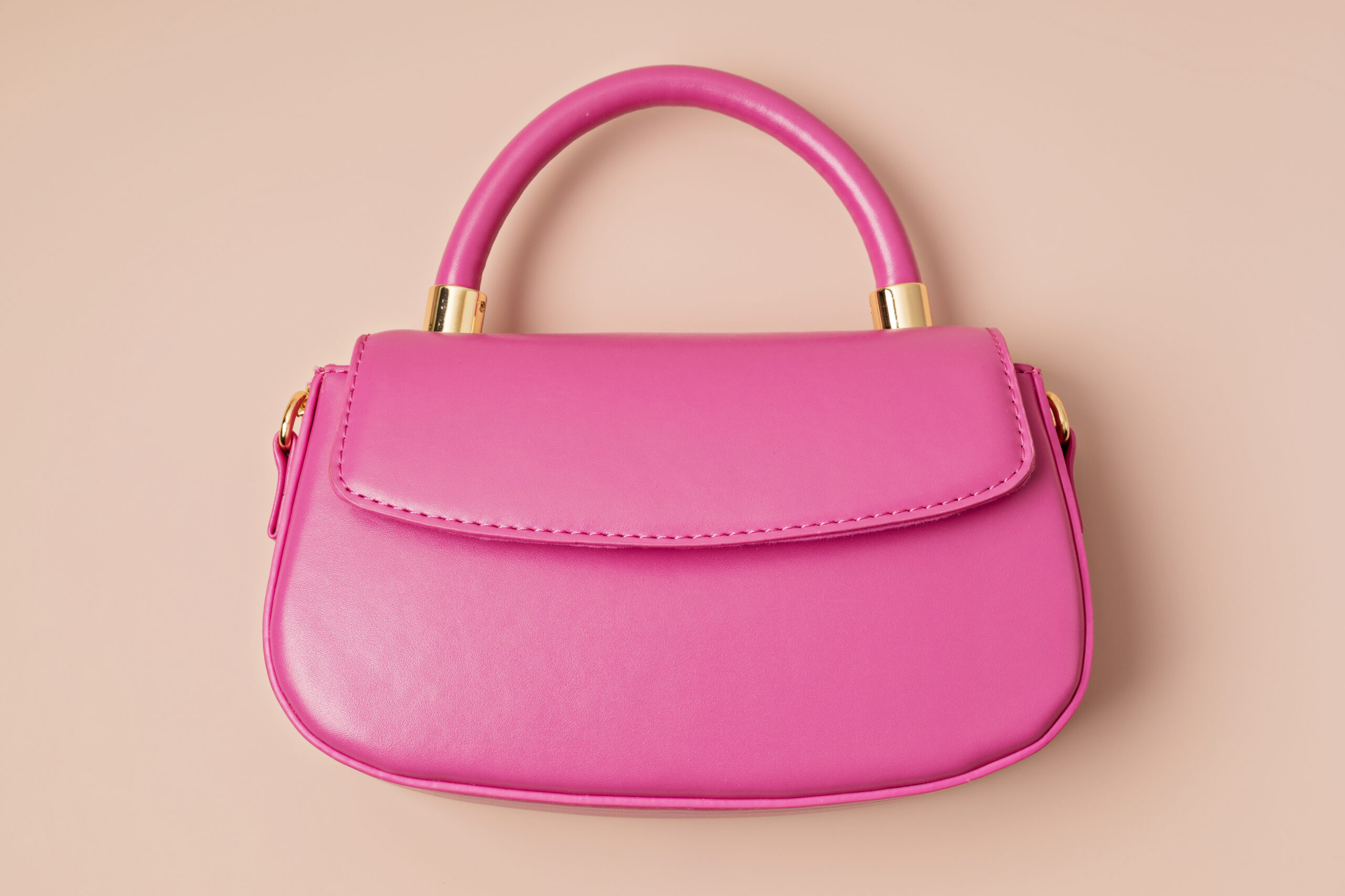 Pastel colored womens hand bag on pink background